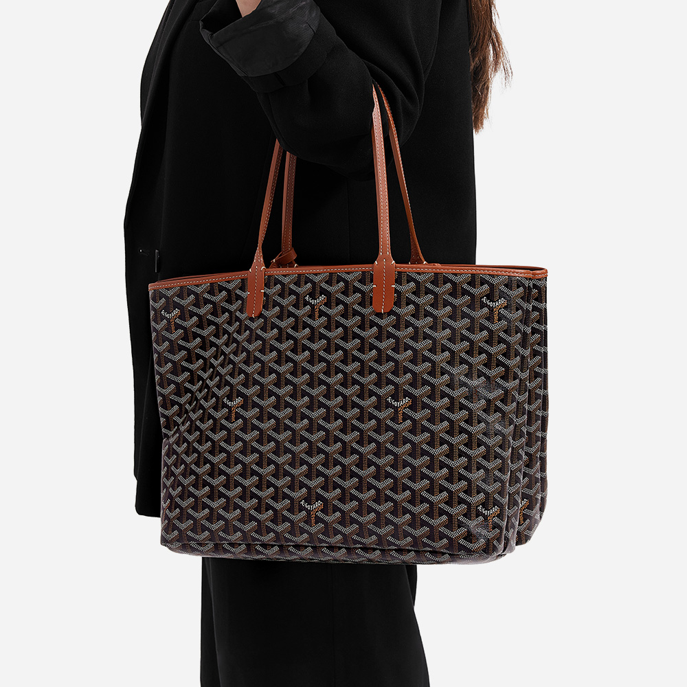 model holding the goyard isablle pm tote in the color gold and black by FASHIONPHILE