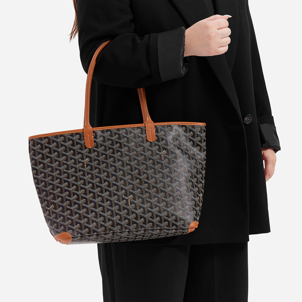 model wearing the goyard artois pm tote on the arm in the color black and gold by FASHIONPHILE