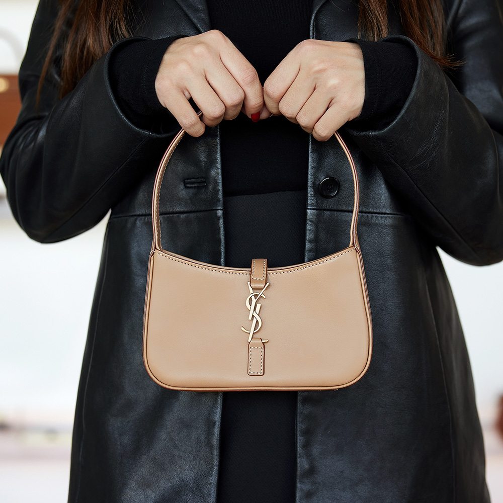 the mini saint laurent hobo bag in beige styled as a top handle by FASHIONPHILE