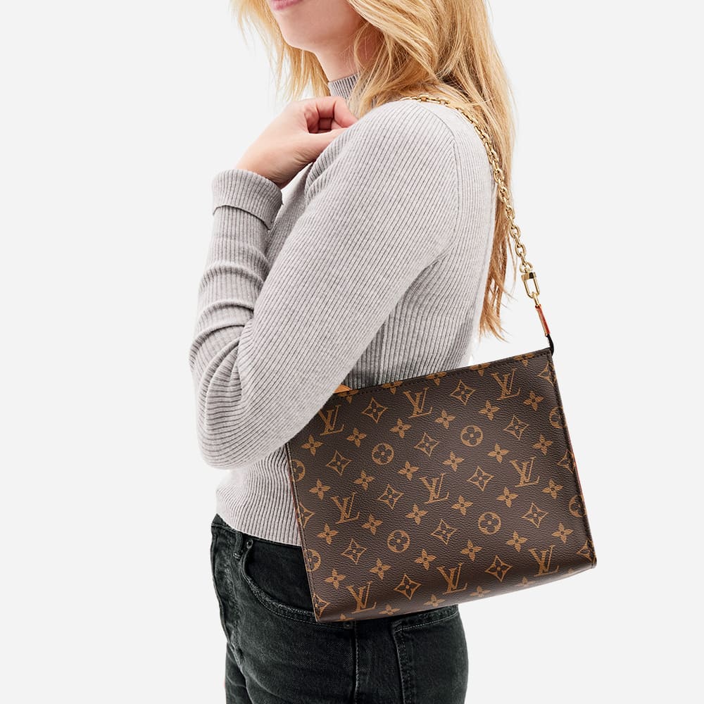 the louis vuitton mongram toiletry pouch on chain worn as a shoulder bag by FASHIONPHILE